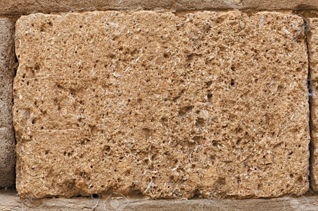 block of tuff on wall of medieval palace - stone texture, single brick of tufa